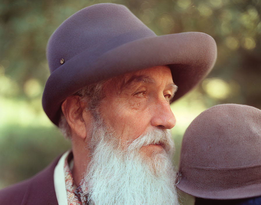 Elderly Man in Purple Hat and Suit with White Beard and Greenery Background