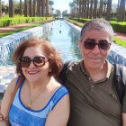 Regal couple in royal attire against serene water garden