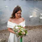 Woman with floral crown and bouquet by seaside waves