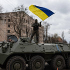 Soldier on Camouflaged Tank with Ukrainian Flag in Forest