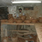 Artisans creating pottery in a clay-filled workshop