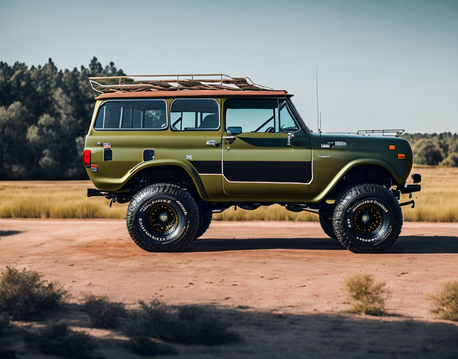 Restored vintage olive green SUV with roof rack parked in nature