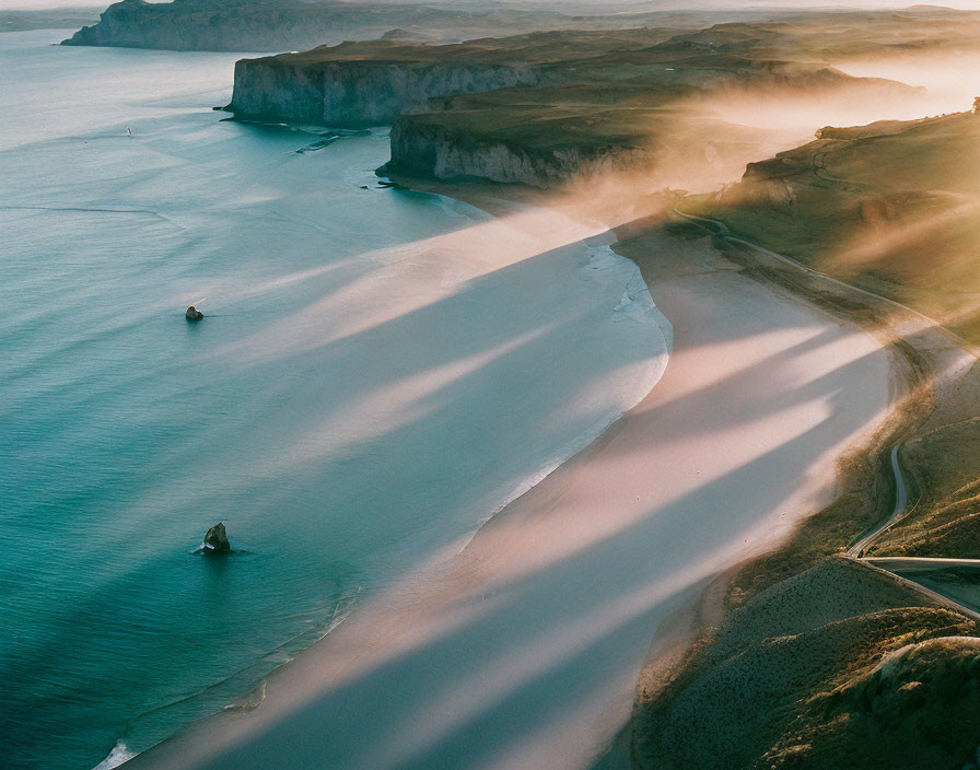 Coastal landscape at sunset: misty cliffs, serene beach, boats on water