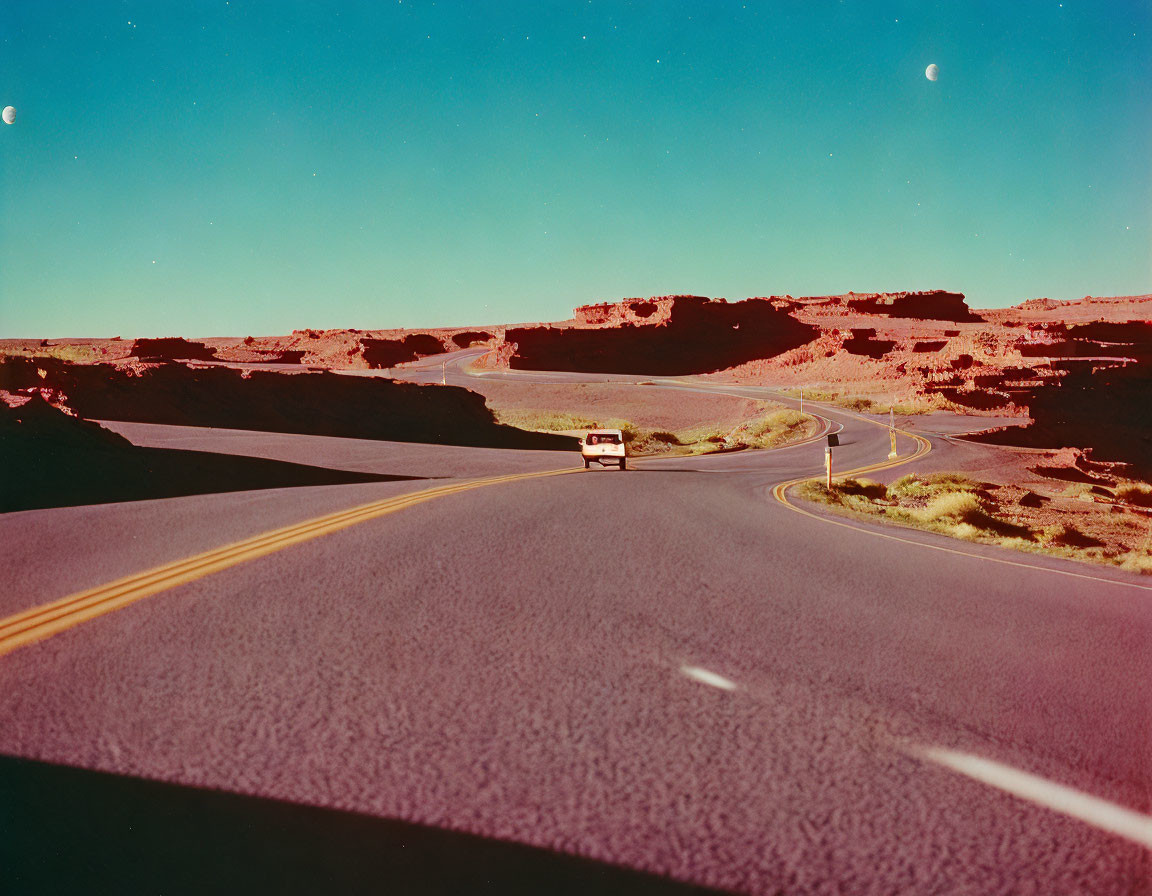 Van driving on winding desert road under crescent moon