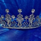 Intricate Golden Tiara with Gemstones on Blue Satin Fabric