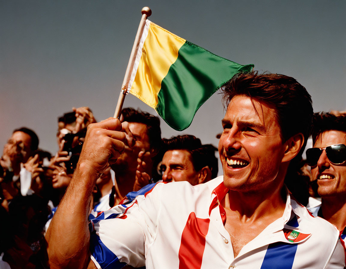 Excited person waving yellow and green flag in a cheering crowd