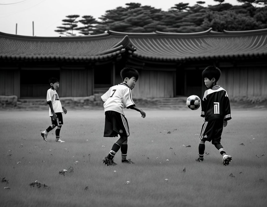 Young soccer players practicing in front of Asian-style building.