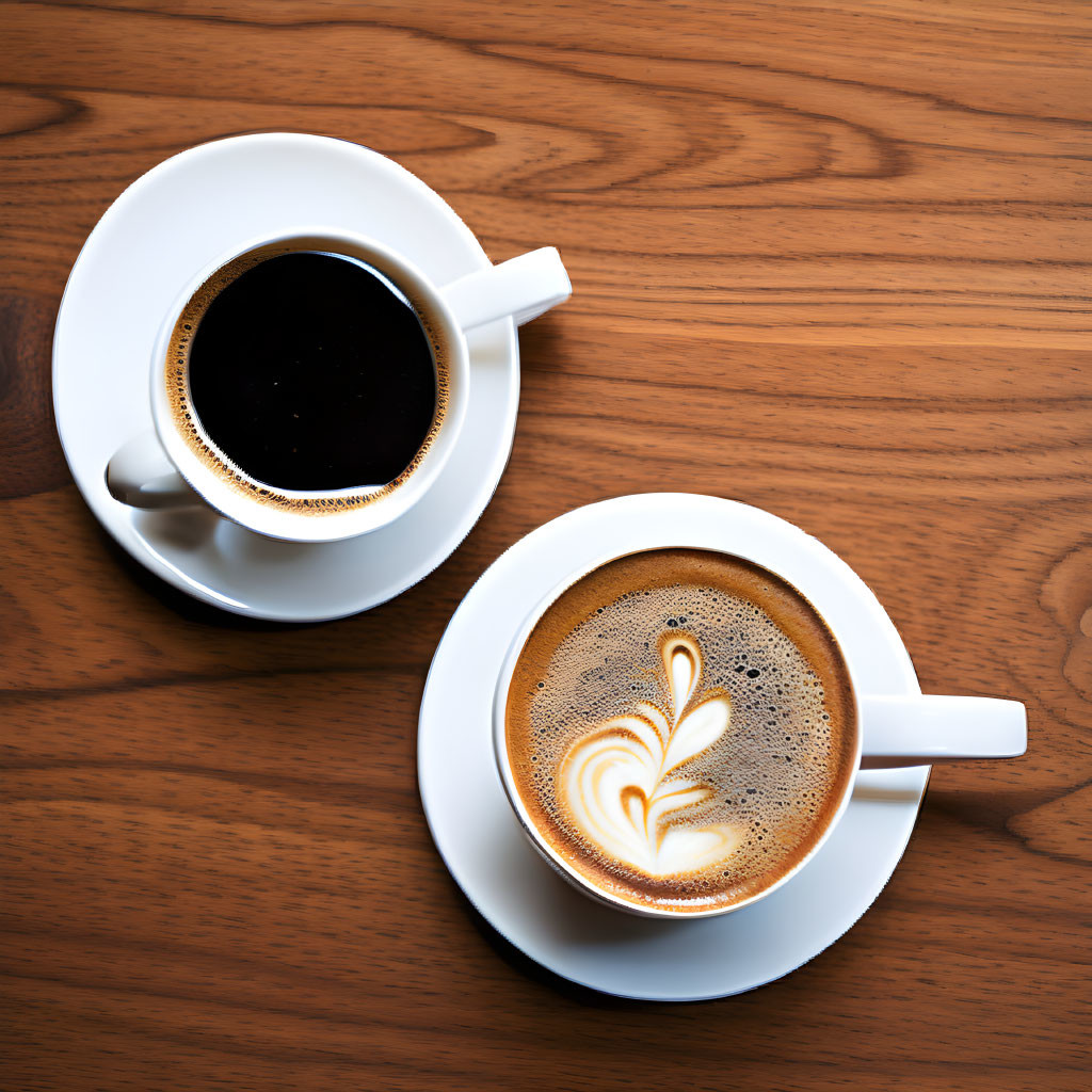 Two Coffee Cups on Wooden Table: Simple vs. Latte Art Leaf