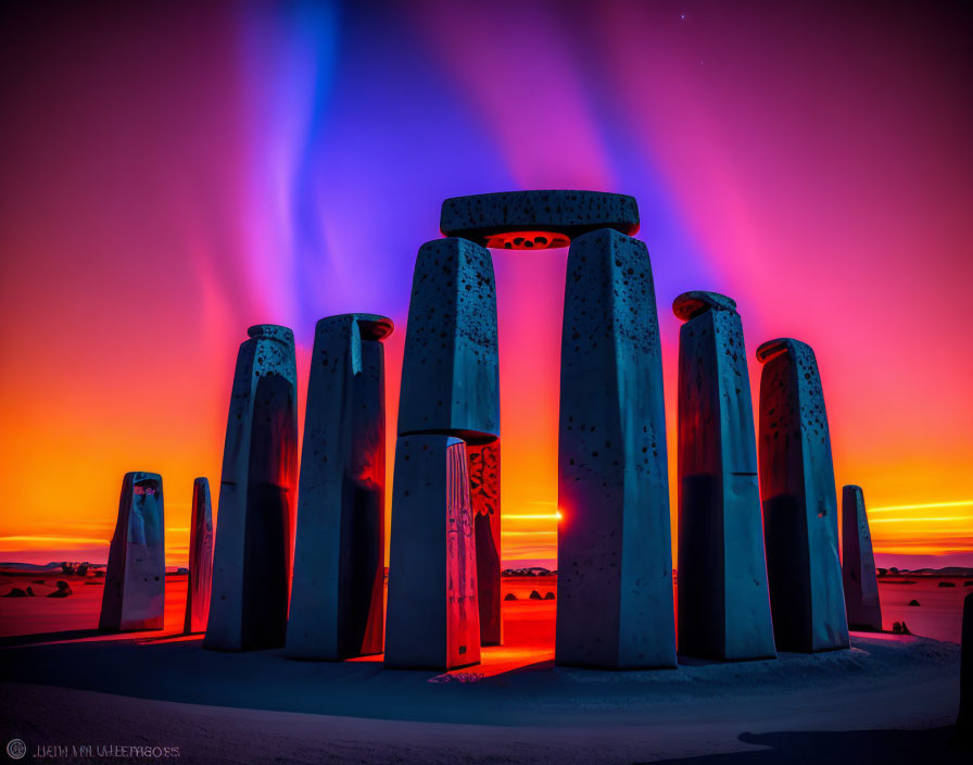 Stonehenge replica lit up by colorful lights under twilight sky with aurora.