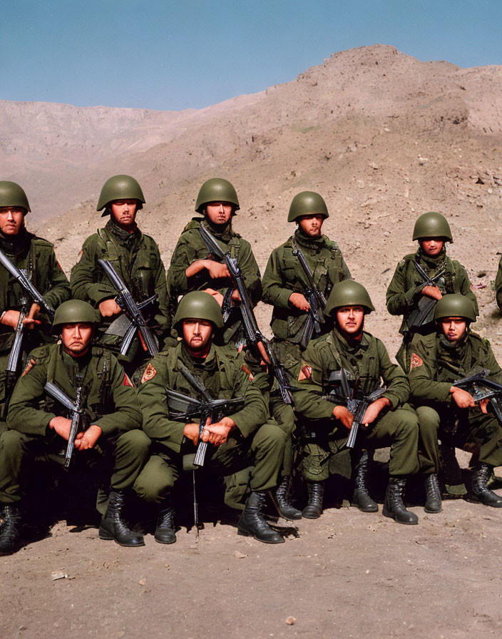 Soldiers in Green Uniforms with Rifles in Mountainous Setting