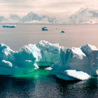 Blue and White Ice Formation Surrounded by Water and Cloudy Sky