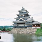 Japanese Castle Surrounded by Cherry Blossoms and Pond