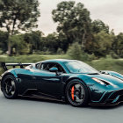 Blue Sports Car with Rear Spoiler Driving Through Green Landscape