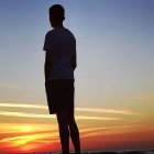 Astronaut in spacesuit against vivid sunset sky