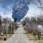 Classic train with large smoke plume in quaint village scenery