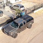 Rugged trucks navigating desert dunes in a cloud of dust