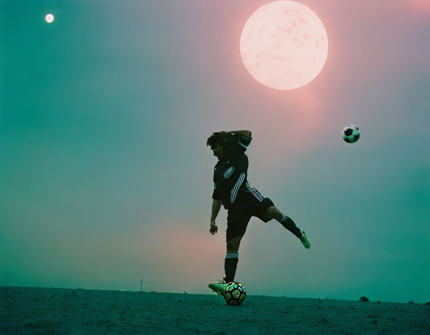 Soccer player kicking ball on sandy field under surreal sky