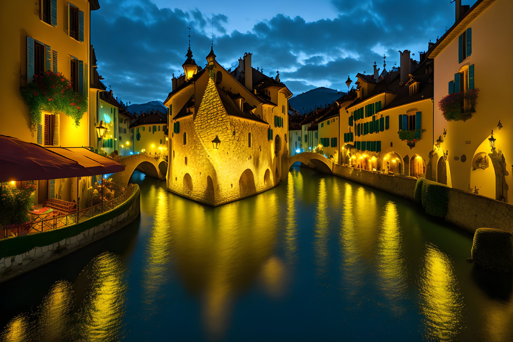 Illuminated castle at dusk reflected in water by canal