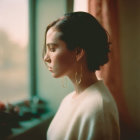 Woman with Bob Haircut Looking Out Window in Sunlight