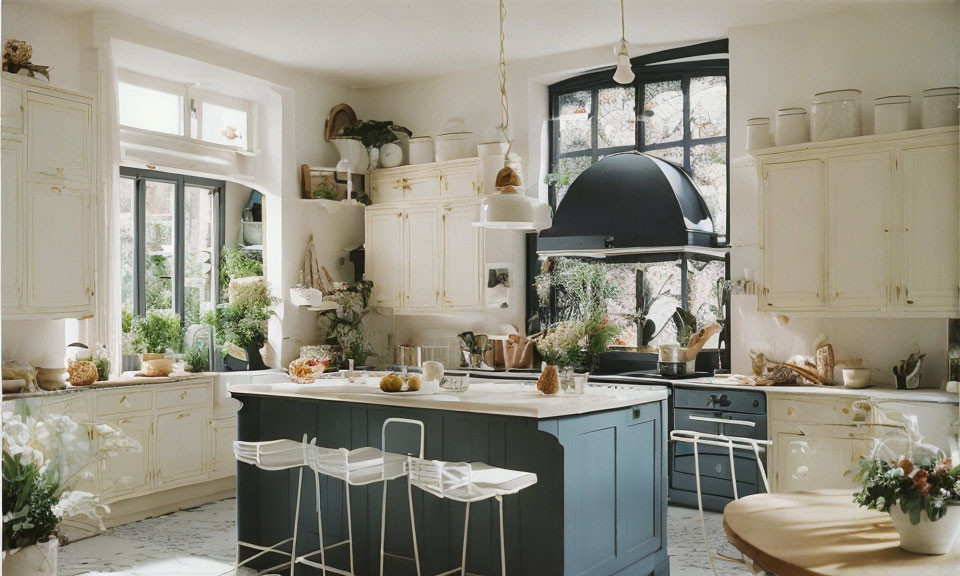 Spacious kitchen with vintage cream cabinetry, central island, black accents, and natural light