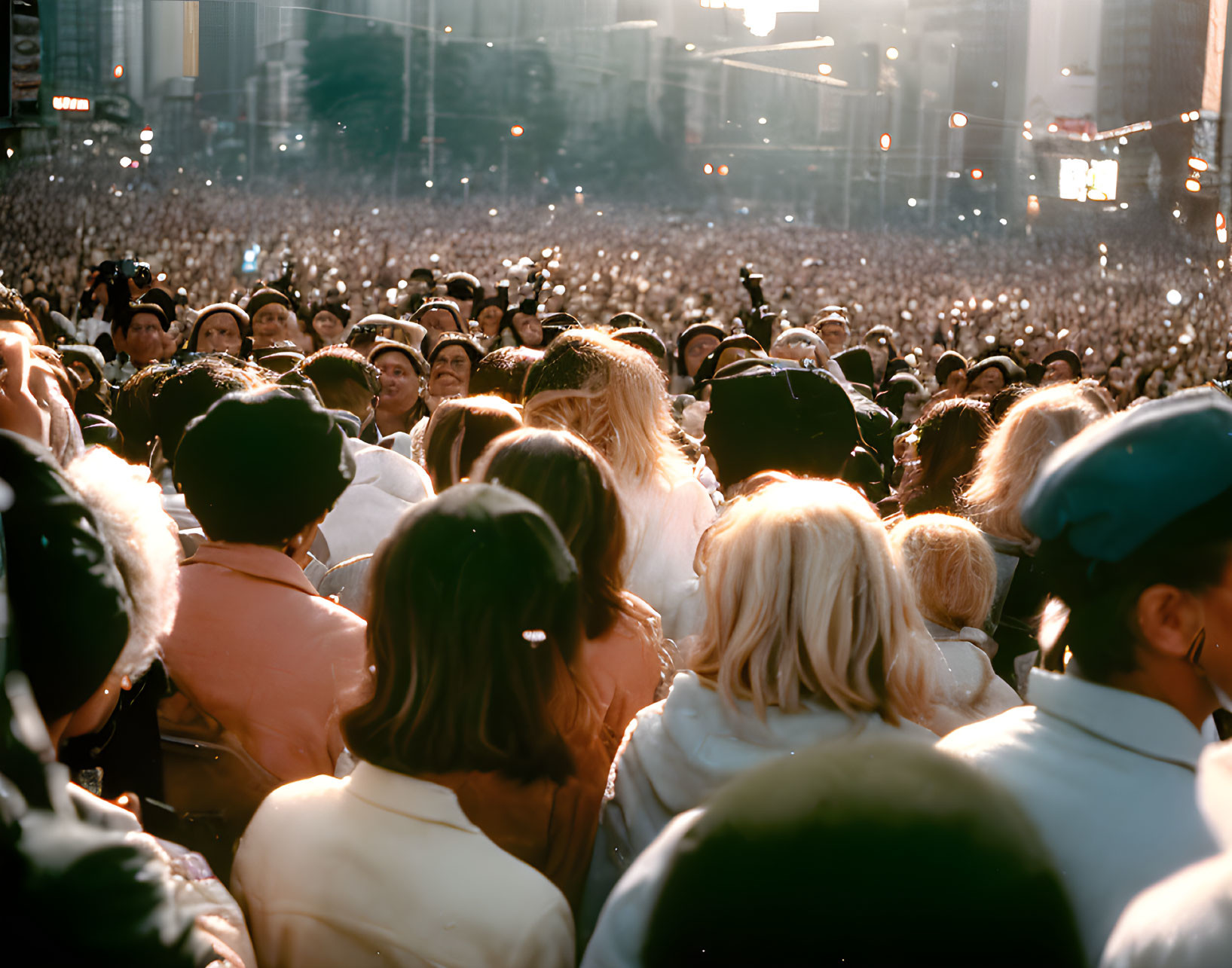 Diverse crowd in golden sunlight facing away outdoors