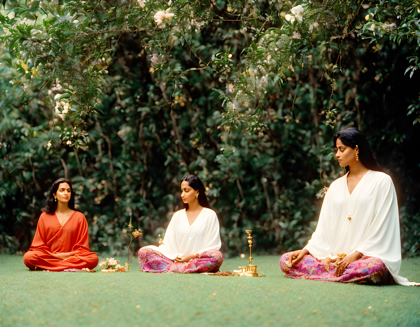 Three People Meditating Outdoors in Traditional Clothing