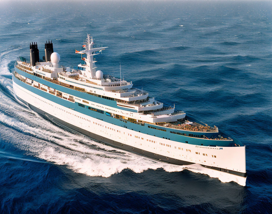 Large cruise ship on vibrant blue ocean with white frothy waves