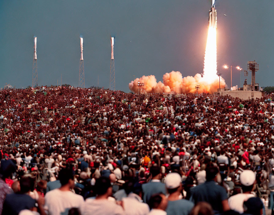 Crowd watches space shuttle launch with billowing smoke.