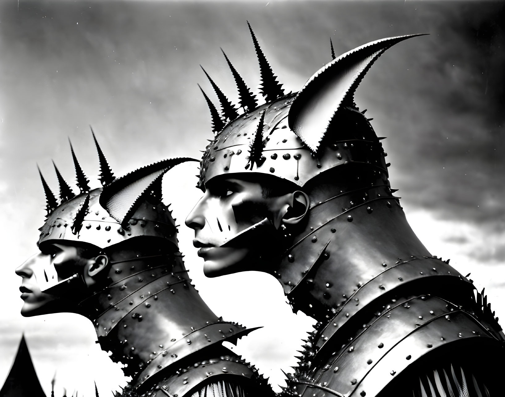 Two individuals in metallic, spiky helmets under dramatic lighting.