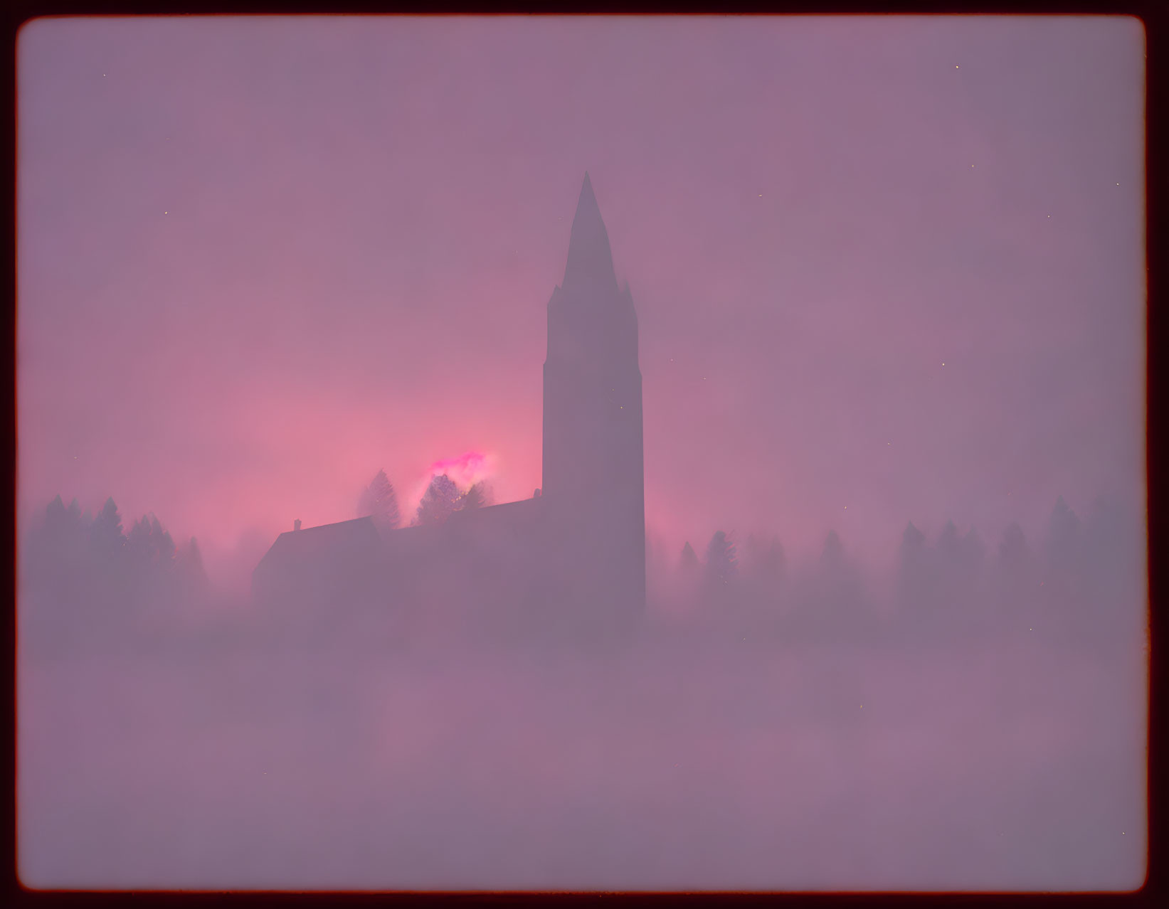 Silhouette of church spire in misty pink sky.