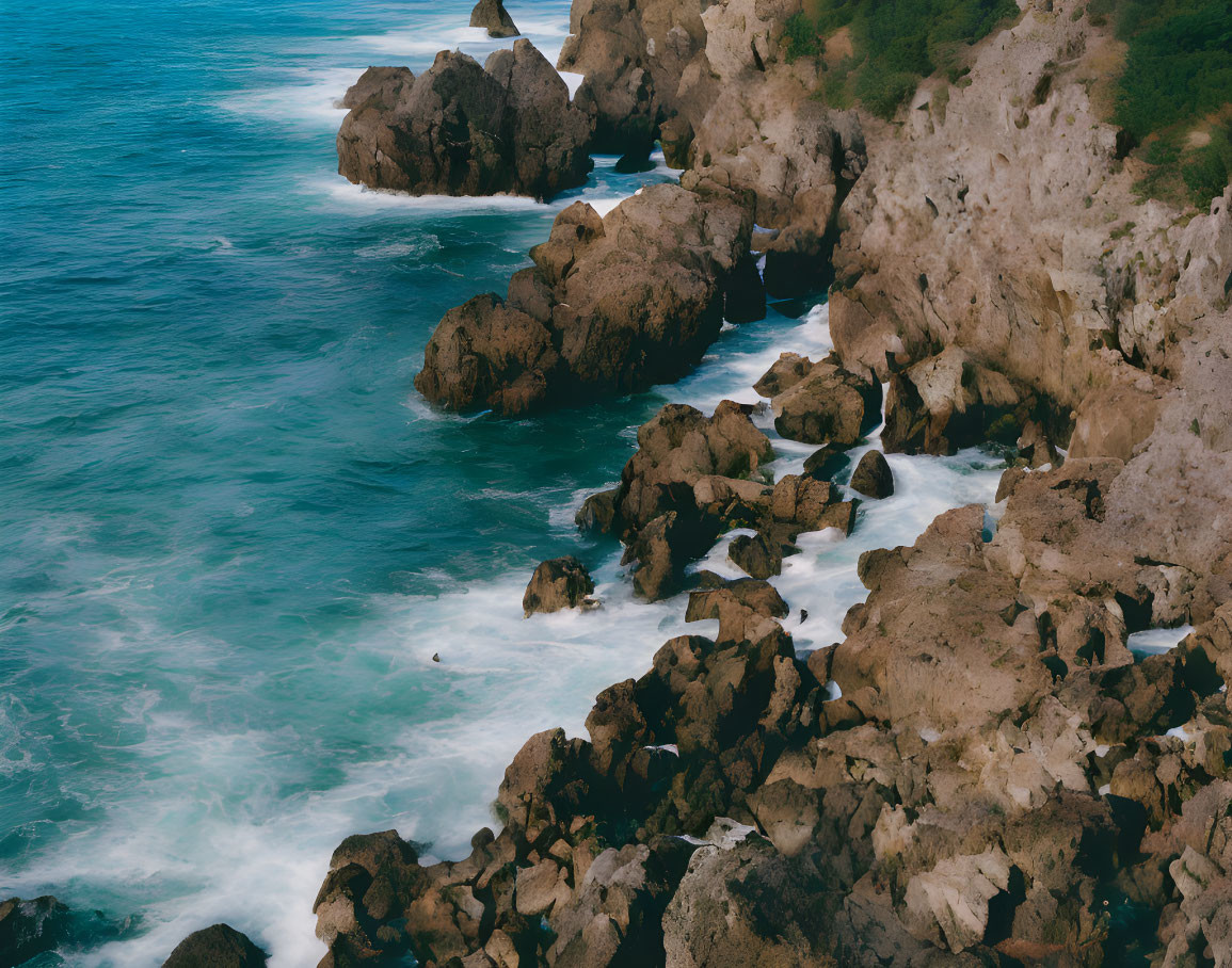 Scenic rocky coastline with jagged cliffs and turquoise ocean waves