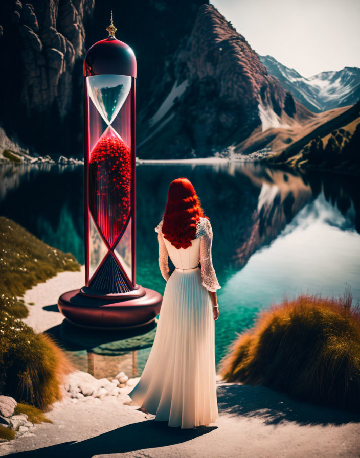 Woman in white dress by hourglass in mountain landscape with lake