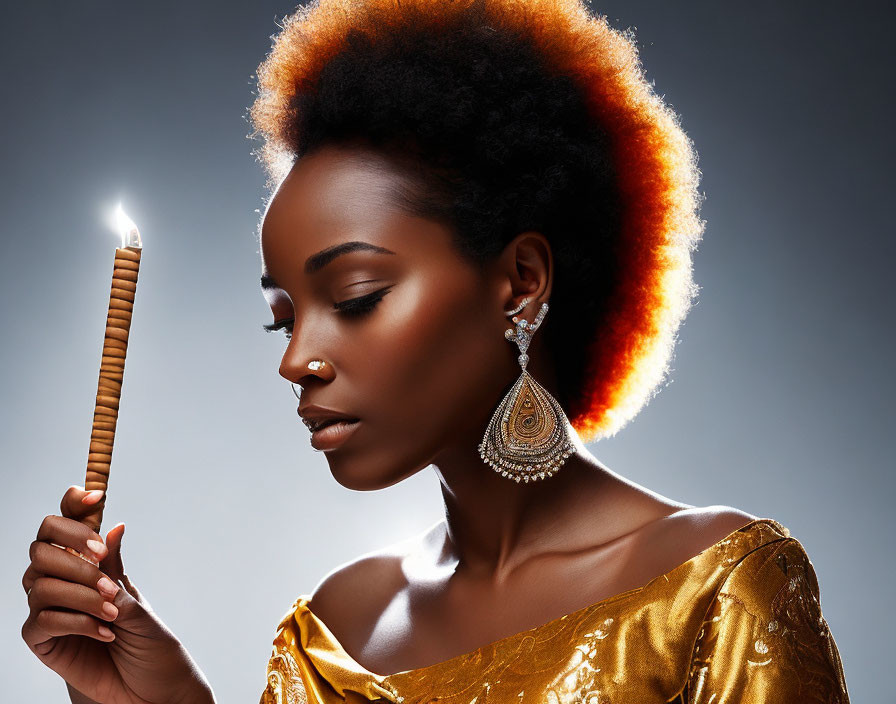Backlit woman with afro holding lit candle in golden attire