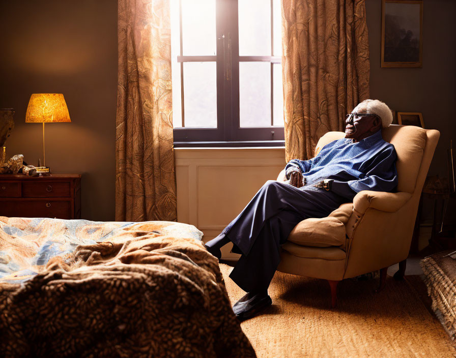 Elderly man in cozy armchair by window with cup in warm sunlight