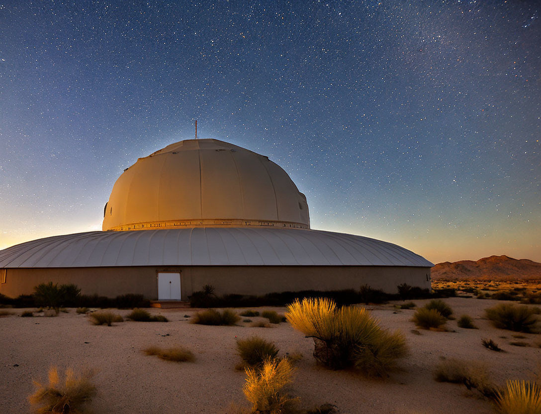 Observatory dome under starry night sky in desert landscape