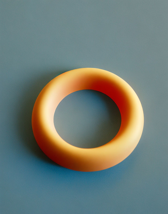 3D rendering of smooth, shiny orange and yellow torus on blue background