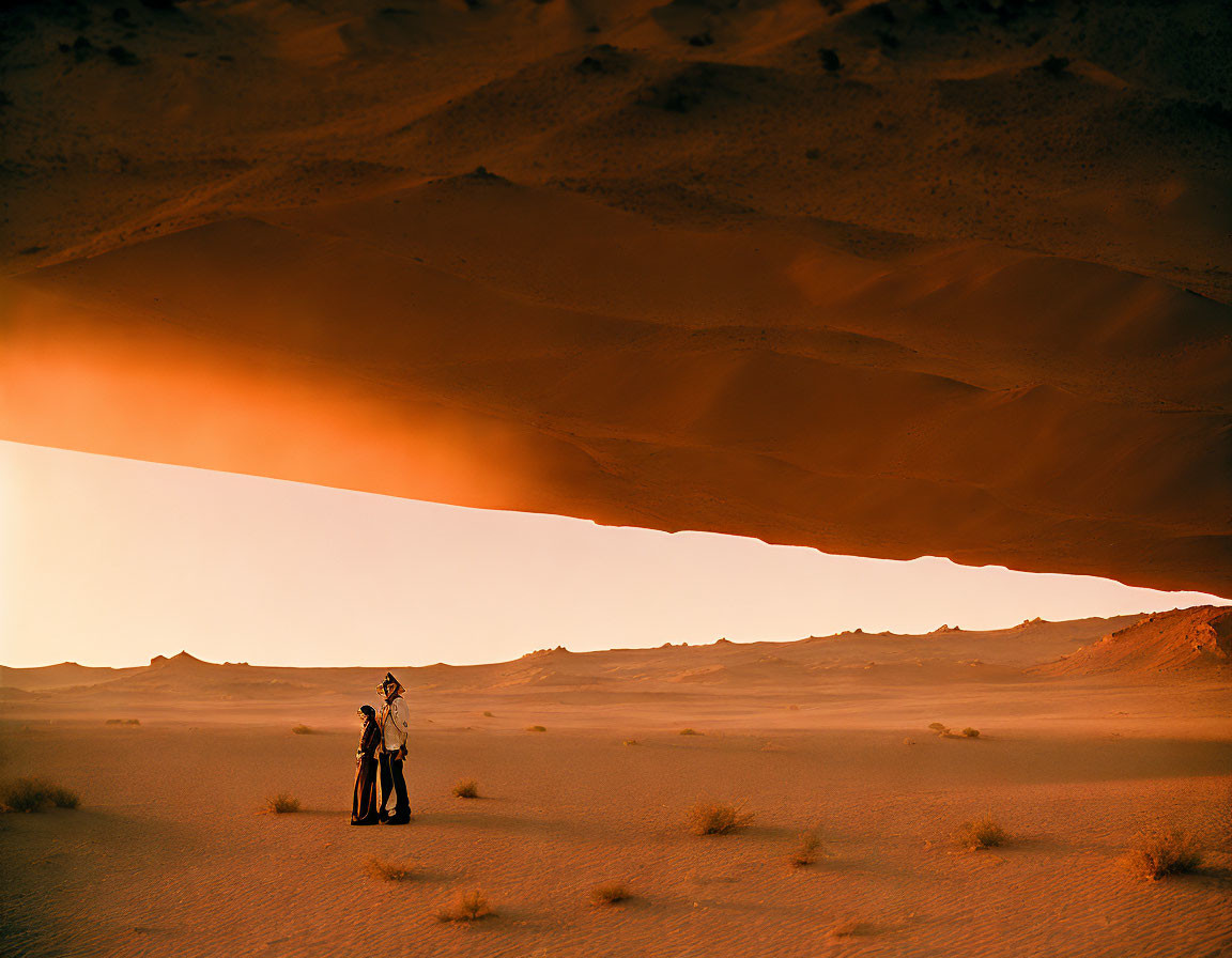 Couple Embraced Under Desert Rock Overhang at Sunset