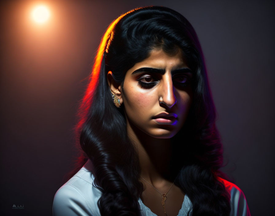 Moody portrait of a woman with dark hair and contrasting warm/cool lighting