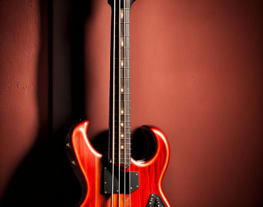 Red Electric Bass Guitar on Dark Background: Body, Fretboard, Curves, and Strings