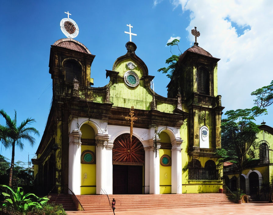 Old Church with Yellow Walls and Twin Bell Towers Against Blue Sky