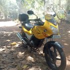 Vintage Motorcycle with Yellow Tank by River and Willow Trees