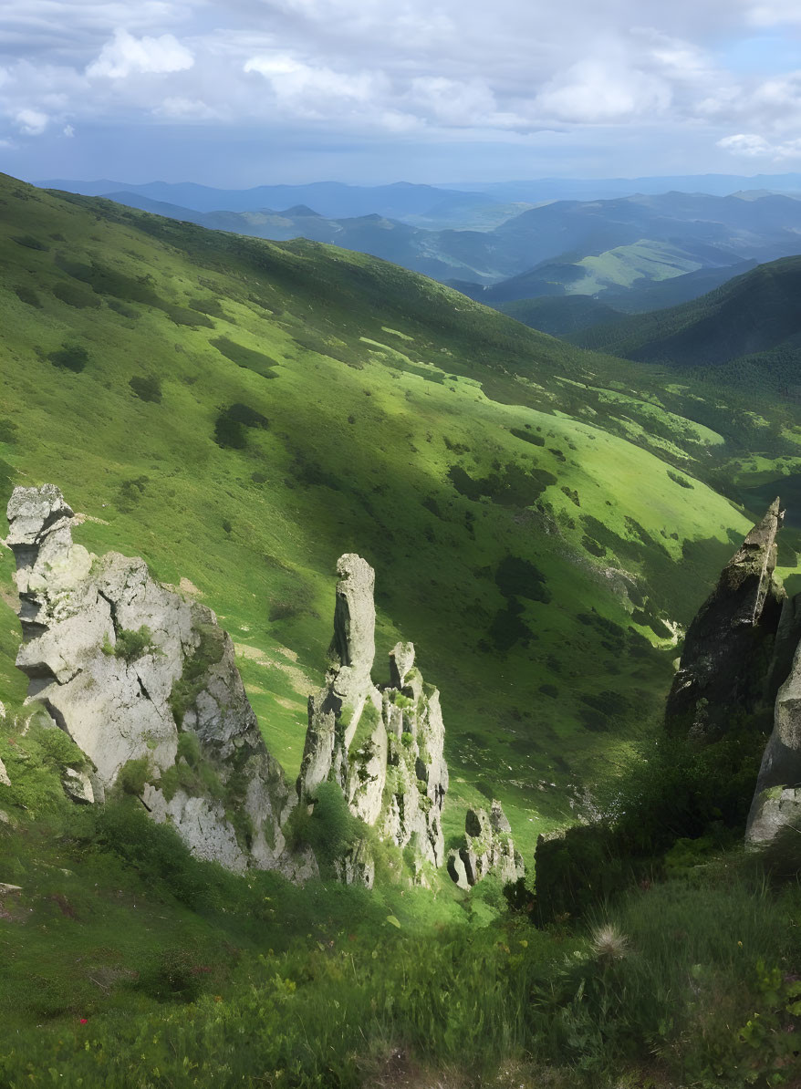 Lush Green Mountain Range with Rocky Outcrops and Cloudy Sky