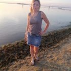 Woman in pink corset surrounded by vibrant flowers at sunset