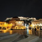 Terraced town at night with illuminated buildings and starry sky