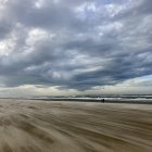 Tranquil beach landscape with gentle waves and cloudy sky