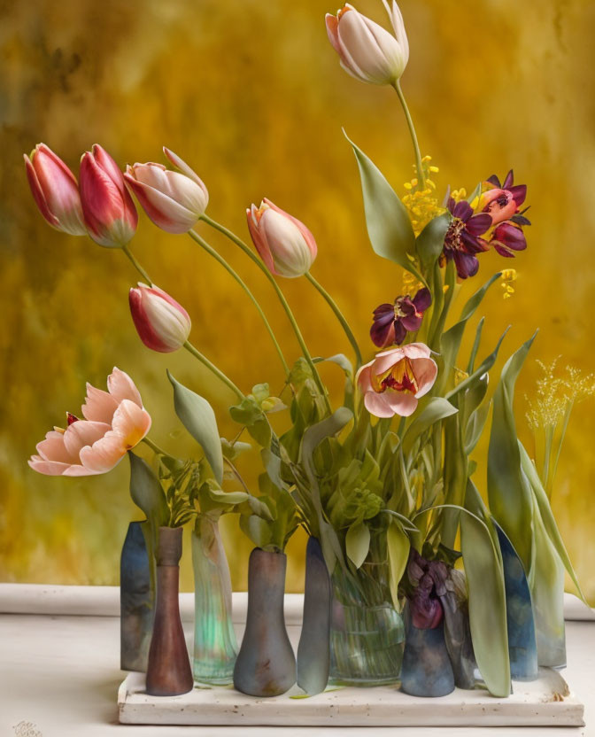 Colorful flowers in blue-gray vases on windowsill against yellow backdrop