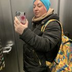 Person in Blue Beanie Selfie Mirror Shot with Phone and Stylish Outfit