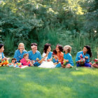 Diverse children smiling in circle on grass in park