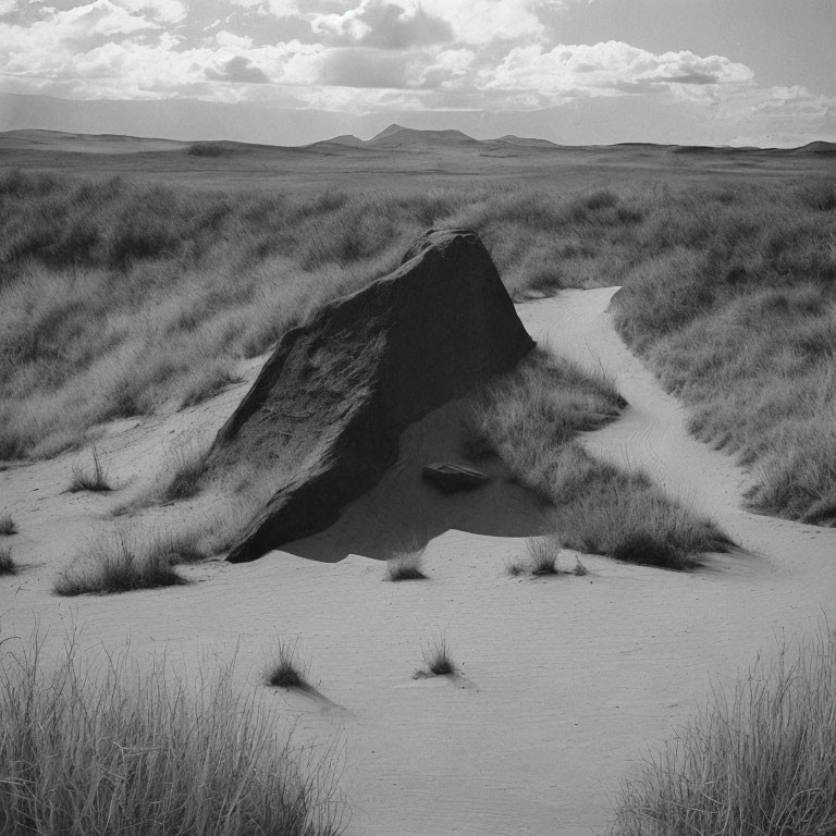 Monochrome photo of rock in desert landscape