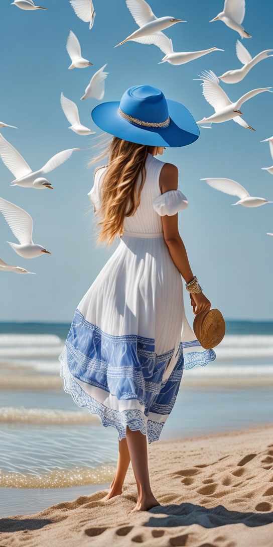 Woman in white and blue dress with wide-brimmed hat on sandy beach with seagulls.